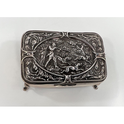 825 - A hallmarked silver hinged box with relief hunting scene to lid, on four feet, Birmingham 1908, leng... 