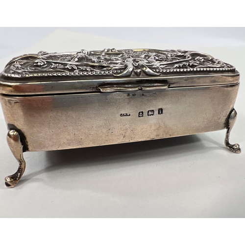 825 - A hallmarked silver hinged box with relief hunting scene to lid, on four feet, Birmingham 1908, leng... 