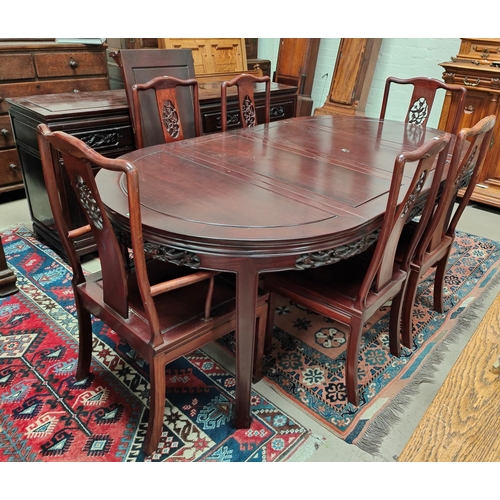 900 - A Chinese hardwood dining suite comprising table with rounded extending top, 3 spare leaves, extende... 