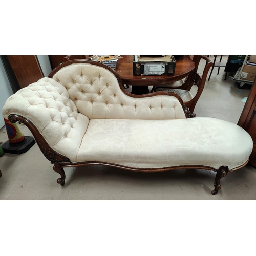 908 - A Victorian carved walnut chaise longue with raised scroll back, on knurled feet and castors, uphols... 