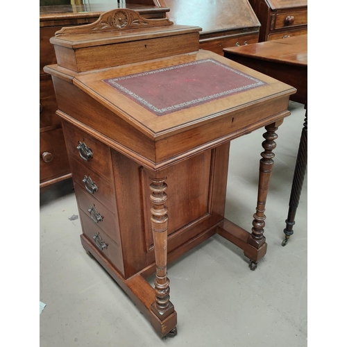 917 - A mahogany davenport with sloped writing surface, letter rack back, drawers to one side, turned supp... 