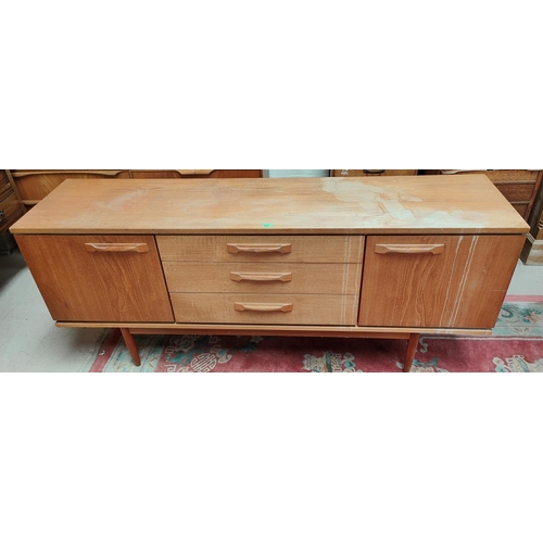 938 - A 1960's teak sideboard of 2 side cupboards and 3 central drawers, length 183cm