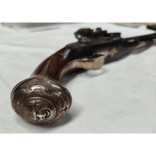 86 - A 19th century flintlock pistol, muzzle loading with white metal mounted decoration and relief carvi... 