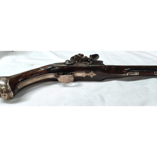 86 - A 19th century flintlock pistol, muzzle loading with white metal mounted decoration and relief carvi... 