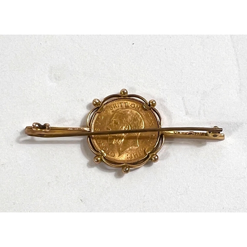 643 - A yellow metal bar brooch stamped 9ct set with George V half sovereign, 6.8gm