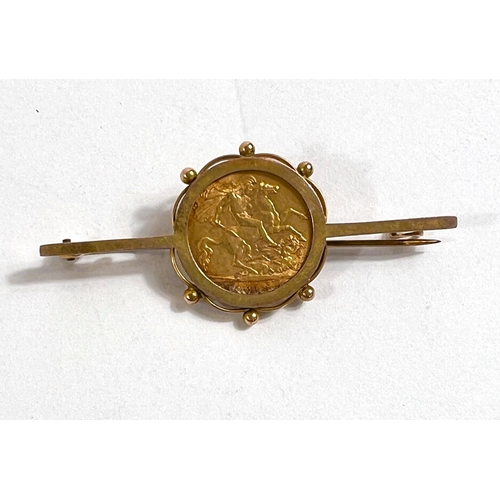 643 - A yellow metal bar brooch stamped 9ct set with George V half sovereign, 6.8gm