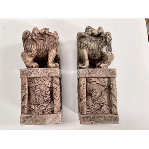 489 - Two large Chinese carved soapstone figures of mythical beasts atop carved stands with seal mark to b... 