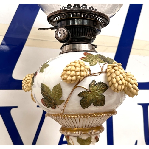 591 - A 19th century Moore's ornate table oil lamp encrusted with flowers and leaves, the column supported... 