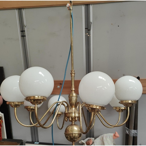 96 - An eight branch central chandelier brass light fitting with opaque light globes, a brass sphere to b... 