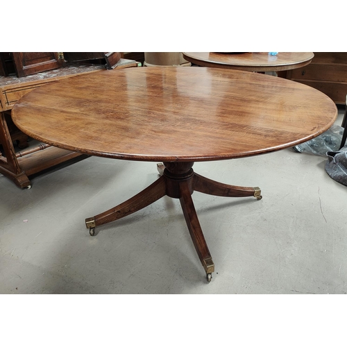 1017 - A circular period style oak pedestal dining table on turned baluster column, 4 splay feet and brass ... 