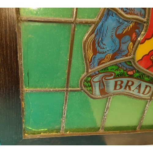 151 - An oak framed stained glass window with the Bradford Coat of Arms surrounded by green glass  49... 