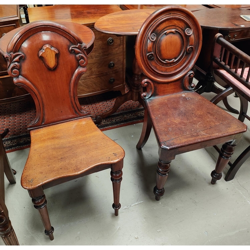 843a - An early 19th century mahogany hall chair with rounded back and a similar shield back hall chair