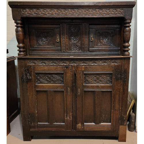 969 - An 18th century oak carved diodarn cupboard with double cupboard above and below, double support col... 