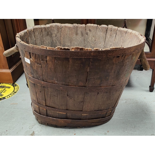 973 - A rustic French grain barrel of ovoid shape, with handles and metal bindings.