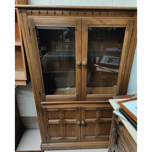 992 - A modern Ercol light wood bookcase with double door bevelled edge glass above and double doors below... 