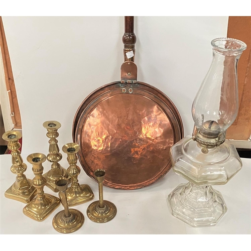 75 - A selection of brass candlesticks, some with push up bases, a copper warming pan and a glass oil lam... 