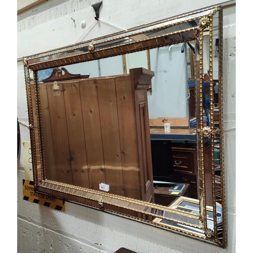 961 - A Venetian style mirror with cushion segmented frame with brass coloured fittings. 58 x 79cm