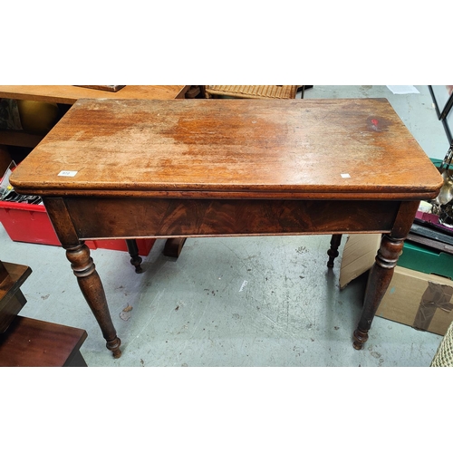 972 - A mahogany fold over card table with turned legs.