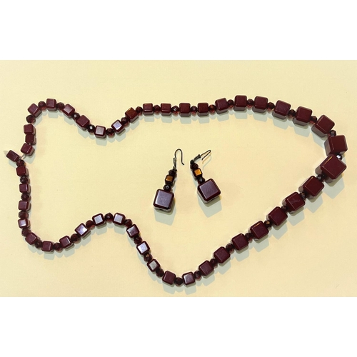 626 - A cherry amber Bakelite necklace of graduating cube form with clear faceted beads between and a matc... 