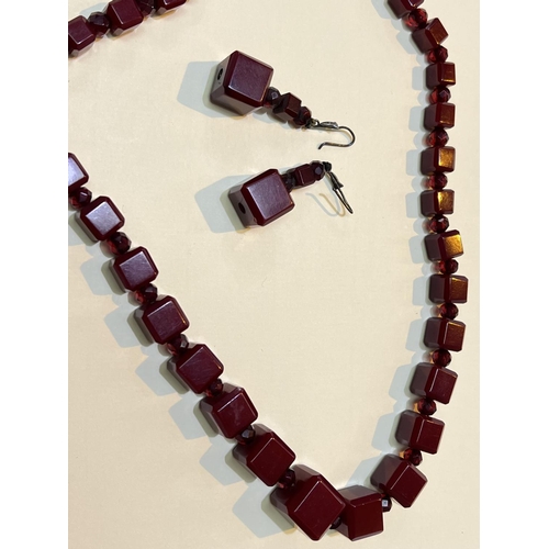 626 - A cherry amber Bakelite necklace of graduating cube form with clear faceted beads between and a matc... 