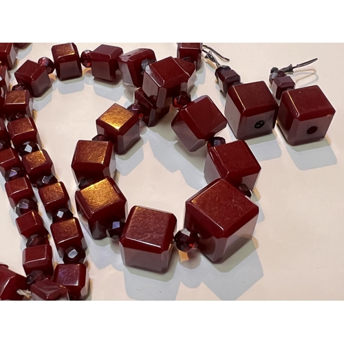 626 - A cherry amber Bakelite necklace of graduating cube form with clear faceted beads between and a matc... 