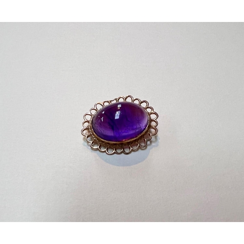 642 - A 9ct gold brooch with large amethyst oval cabochon stone with lace border, gross weight 4.6gms.