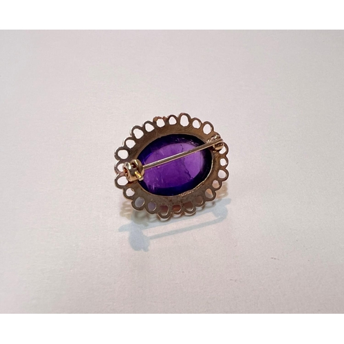 642 - A 9ct gold brooch with large amethyst oval cabochon stone with lace border, gross weight 4.6gms.