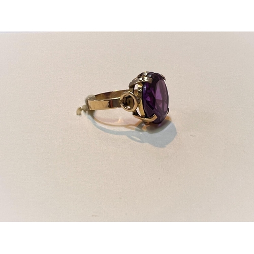 644 - A yellow metal ring with large amethyst stone, Egyptian marked, weight 5.9gms, size M.