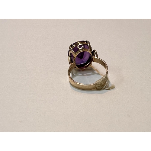 644 - A yellow metal ring with large amethyst stone, Egyptian marked, weight 5.9gms, size M.