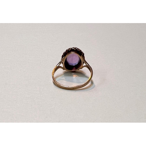 645 - A 9ct gold ring with an oval faceted stone and a roped border, size L, weight 2.6gms.