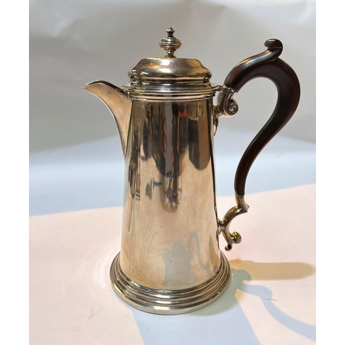 699 - A hallmarked silver hot water jug with hinged lid, shaped handle on stepped foot, Sheffield , 13.3oz