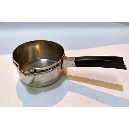 701 - A 19th century white metal, possibly French, brandy sauce pan with ebonised squared handle, with rel... 