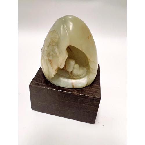 459B - A Chinese Jade coloured hard stone, carved egg shaped piece with carved decoration with cave like fo... 