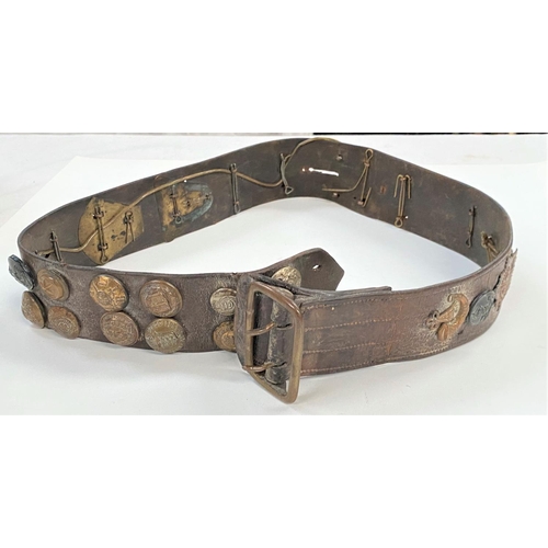 377 - A WWI belt with various badges and buttons attached 