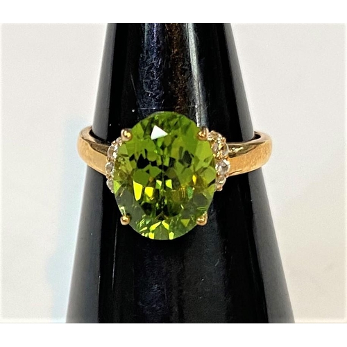 687 - A 9 carat hallmarked gold dress ring set large red dragon peridot, 3.97 carat, and 5 white zircons t... 