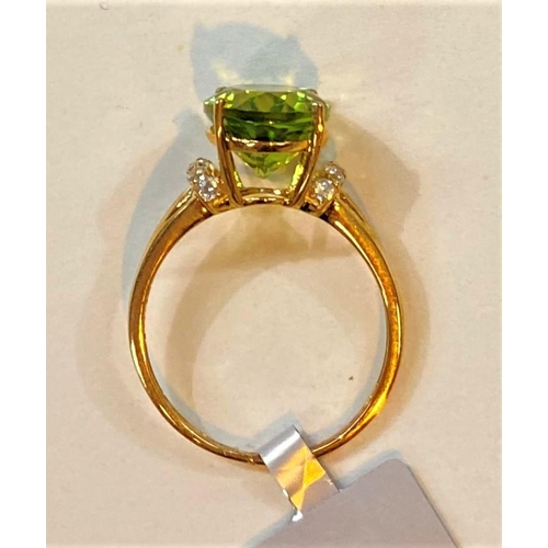 687 - A 9 carat hallmarked gold dress ring set large red dragon peridot, 3.97 carat, and 5 white zircons t... 