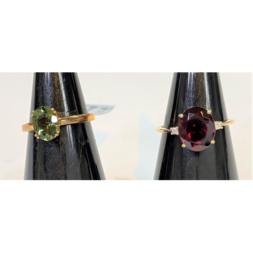 688 - A 9 carat hallmarked gold dress ring set large oval Tocantin garnet with small diamond to each shoul... 