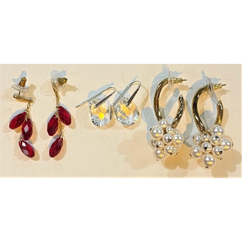 711 - Three pairs of Swarovski earrings:  1 single clear crystal; 1 triple red crystal drops; 1 ... 