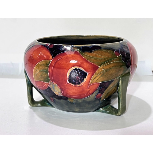 528 - A Moorcroft circular bowl in the Art Deco style, pomegranate pattern, on 3 buttress feet, impressed ... 