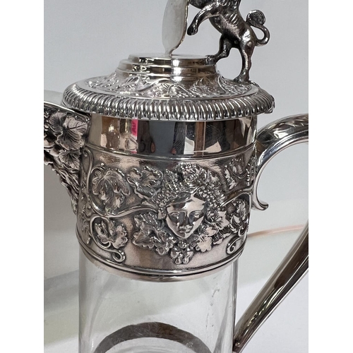 658 - A Victorian cut glass claret jug with hallmarked silver mount and handle, with relief decoration of ... 