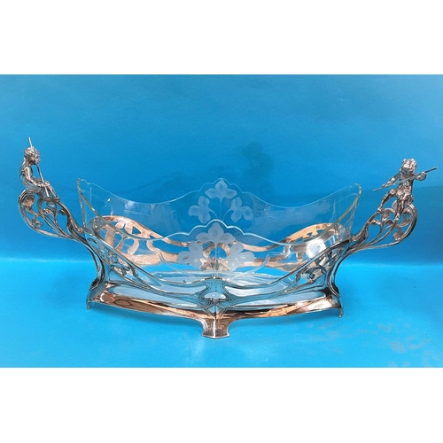 690A - A WMF Art Nouveau table centre in a boat shape with centre etched floral decoration, two Putti figur... 