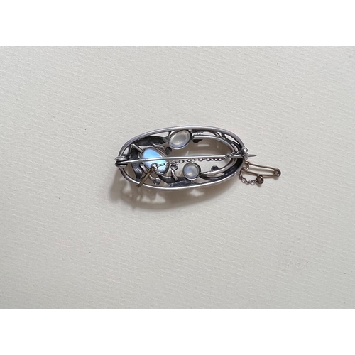 763A - An elongated pierced oval Art Nouveau style white metal brooch formed from leaves / flower set with ... 