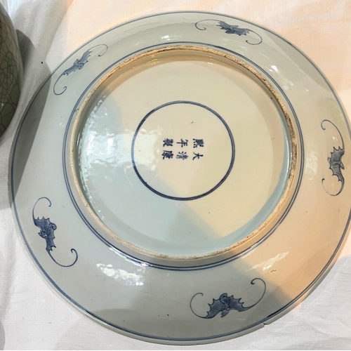 435 - A large blue and white charger with central trio of dragon decoration, bats to outer under rim with ... 