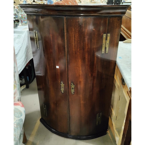 987 - An 18th century mahogany bow front 2 door corner cupboard.