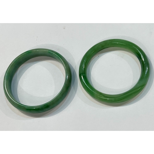 458 - Two Chinese spinach green jade coloured hoop bangles, diameter 8cm