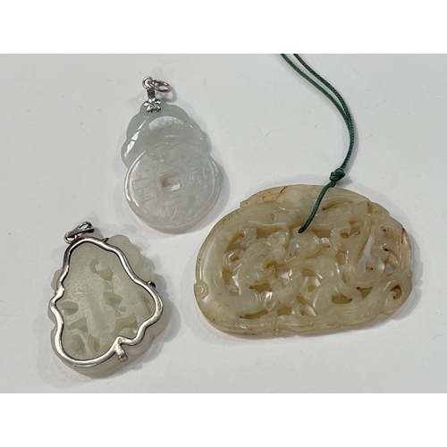 496 - Three Chinese jade coloured pendants, one with metal mounting and two others.