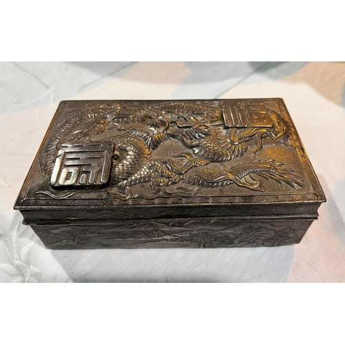 509 - A Japanese white metal box (un marked) decorated with dragons in relief, mountain scenes to sides (h... 