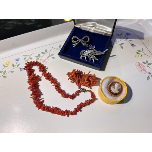 695 - A cameo brooch surrounded by coral beads; a pair of silver clip earrings with amber cabochon and sil... 