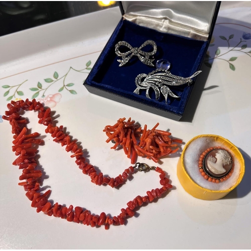 695 - A cameo brooch surrounded by coral beads; a pair of silver clip earrings with amber cabochon and sil... 