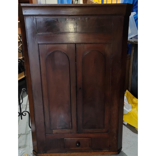 998A - A Georgian mahogany corner cupboard with double arched doors